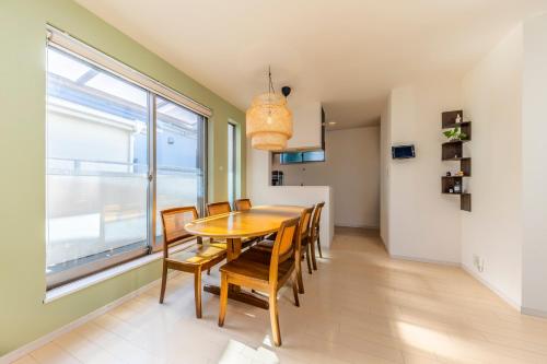 a dining room with a table and chairs and a window at Jin's Place - 15m to Haneda & Shinagawa in Tokyo