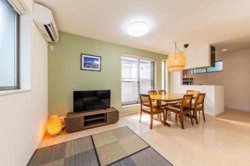 a kitchen and dining room with a table and a television at Jin's Place - 15m to Haneda & Shinagawa in Tokyo