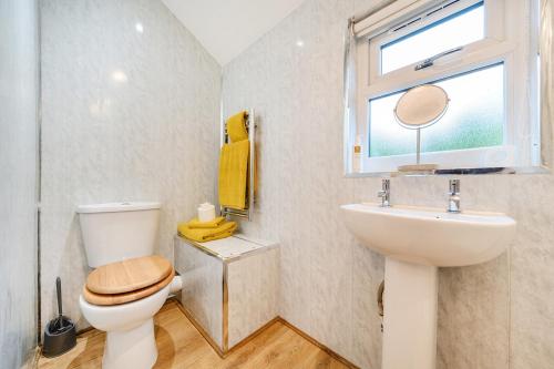a bathroom with a toilet and a sink and a window at Ash Lodge in Ulverston