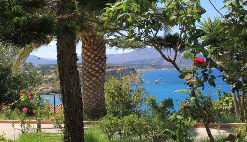 two palm trees with a view of a body of water at Villa Irini in Almirida