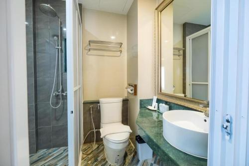 ein Badezimmer mit Toilette, Waschbecken und Dusche in der Unterkunft LANDMARK NAKHONPHANOM HOTEL in Nakhon Phanom
