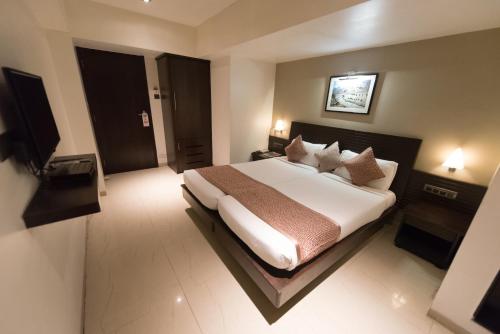 a bedroom with a large bed in a hotel room at Hotel Le Grande - Mumbai International Airport in Mumbai