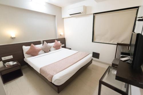 a bedroom with a bed and a projection screen at Hotel Le Grande - Mumbai International Airport in Mumbai