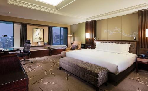 重庆DoubleTree by Hilton Chongqing - Guanyinqiao CBD的一间配有大床和书桌的酒店房间