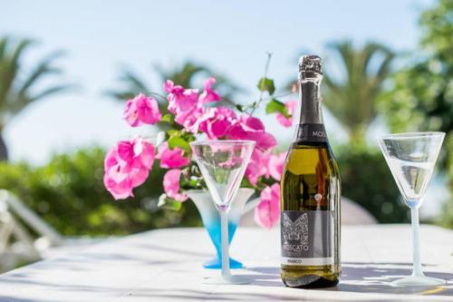 eine Flasche Champagner und zwei Gläser auf dem Tisch in der Unterkunft Casa Sol e Praia in Luz