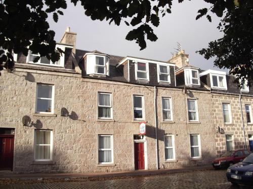 a large brick building with a red door at Abacus Central Guest House in Aberdeen