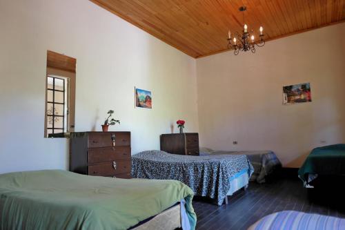 1 dormitorio con 2 camas y lámpara de araña en Casa Seibel, en Quetzaltenango