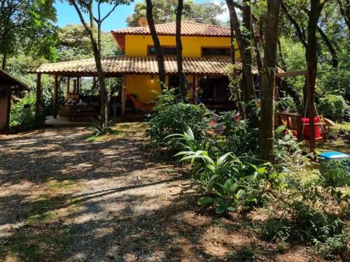 a house in the middle of a yard with trees at Bangalô Rústico Duplex - Retiro Andaluz in Brumadinho