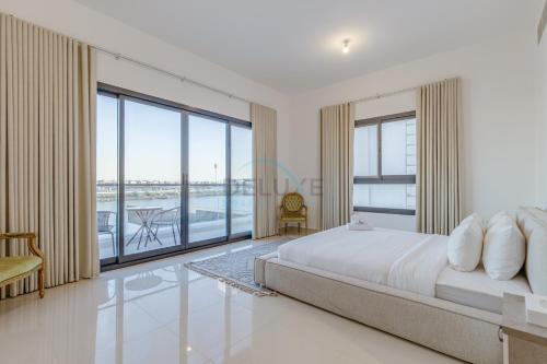 富查伊拉Grand 4BR Villa with Majestic Mountain and Sea Views, Assistant Room, and Private Pool, Just a Few Minutes Drive from Fujairah Finest Beaches and Camping Sites, Al Dana Island, Fujairah by Deluxe Holiday Homes的一间带大床的卧室和一个阳台