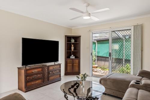 a living room with a flat screen tv and a coffee table at Swainson on Fontaine in Sellicks Beach