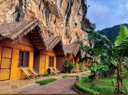a building with a mountain in the background at Tràng An Valley Retreat in Nguyên Ngoại
