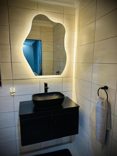 a bathroom with a black sink and a mirror at Y & N BnB in Alberton
