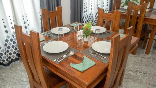 uma mesa de madeira com pratos e guardanapos em Sigiriya Agrarian Haven em Dambulla