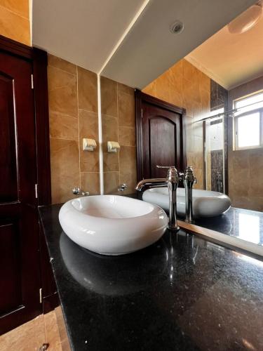 ein Badezimmer mit zwei Waschbecken und zwei Armaturen in der Unterkunft Urban 2 Bedroom Serviced Apartment in Nakasero in Nalakonge
