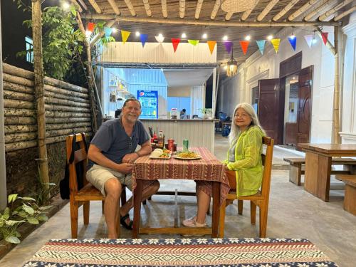 Cừ LạcにあるDiscovery Lodge Phong Nhaのテーブルに座っている男性と女性