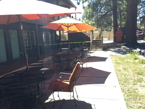an outdoor patio with tables and chairs with umbrellas at Robinhood Resort in Big Bear Lake