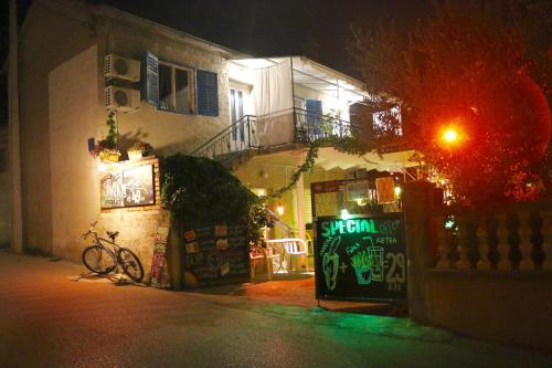 a building with a sign on the side of it at night at Guest house Mediterranea in Pakoštane