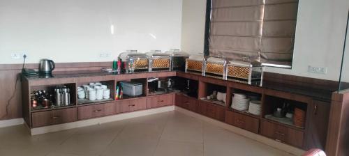 Hotel Buddha Residency的厨房里有一个木架子，上面放着餐具。