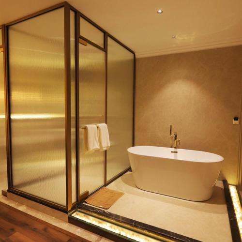 a bathroom with a bath tub and a shower at Hotel Ganga Sutra in Haridwār