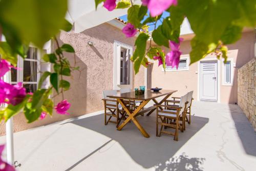 a table and chairs on a patio with pink flowers at Rena's House in Spílion