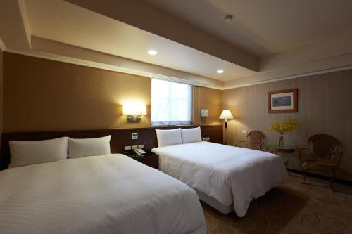 a hotel room with two beds and a window at Good Life Hotel - Shang Hwa in Taipei