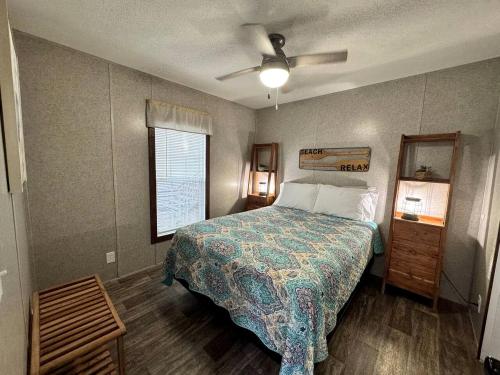 ein Schlafzimmer mit einem Bett und einem Deckenventilator in der Unterkunft Cozy Cottage with River Access for a Fun-Filled Getaway by the Rainbow River in Florida in Dunnellon