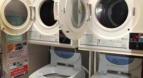 Un baño con lavadora y un inodoro. en Hotel Park Inn Toyama, en Toyama