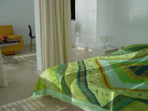 Un dormitorio con una cama con una colcha colorida encima. en SEANGEL HOUSe, en Diklo