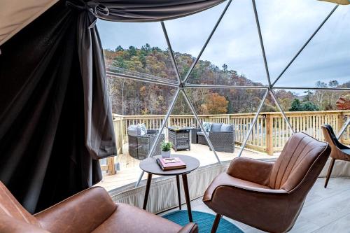 eine abgeschirmte Veranda mit Stühlen und einem Tisch in der Unterkunft Romantic Geodesic Dome with Hot Tub, Perfect for Stargazing in Pipestem, West Virginia in Pipestem