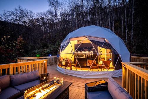 ein Pavillon auf einer Terrasse mit einer Couch in der Unterkunft Romantic Geodesic Dome with Hot Tub, Perfect for Stargazing in Pipestem, West Virginia in Pipestem