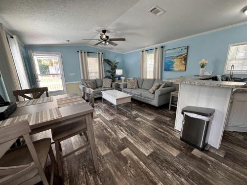 eine Küche und ein Wohnzimmer mit blauen Wänden und einem Tisch in der Unterkunft Modern Cottage with Incredible Amenities and Rainbow River Access near Dunnellon, Florida in Dunnellon
