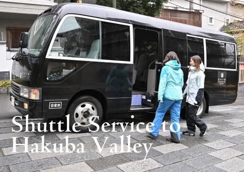 two girls are standing outside of a black van at Matsumoto Jujo in Matsumoto