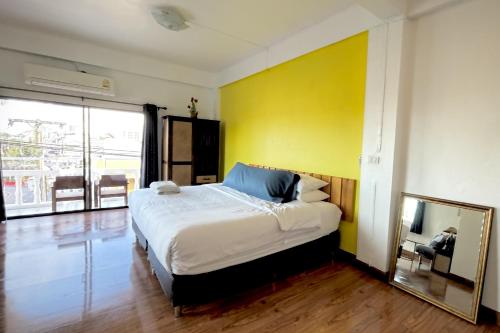 a bedroom with a large bed and a mirror at The Yak Cozy Chiang Mai in Chiang Mai
