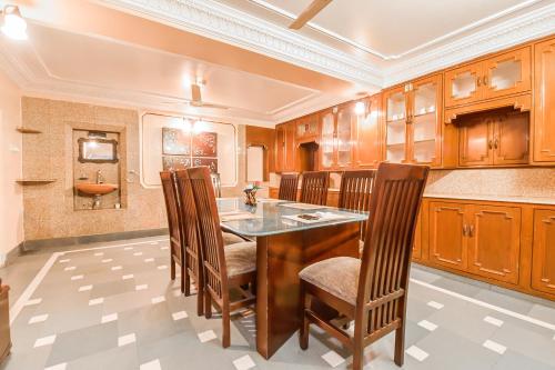 a kitchen with wooden cabinets and a table and chairs at FabHotel Pink Cozzy in Jaipur