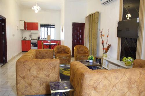 een woonkamer met een bank en stoelen en een keuken bij ftrealtyproperties Tango Suites 6 in Burma Camp