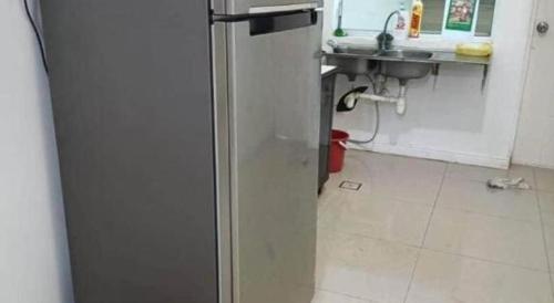 einen Kühlschrank in einer Küche mit Spüle in der Unterkunft OYO HOME 90769 Flo Inn Homestay Bsi in Kampong Parit