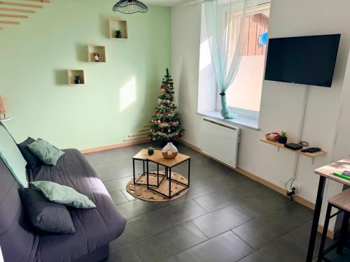 a living room with a christmas tree and a couch at Très bel appartement au cœur des Vosges in Saulcy-sur-Meurthe
