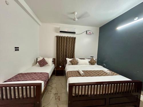 a room with two beds in a room at De villa Auro in Puducherry
