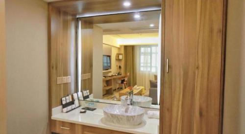 ein Badezimmer mit zwei Waschbecken und einem großen Spiegel in der Unterkunft Borrman Hotel Zhenjiang Dashikou Suning Plaza in Zhenjiang