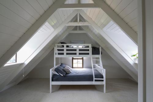 a room with a bunk bed in a attic at Seaviews and a stroll to Whanagaumu bay in Whangarei