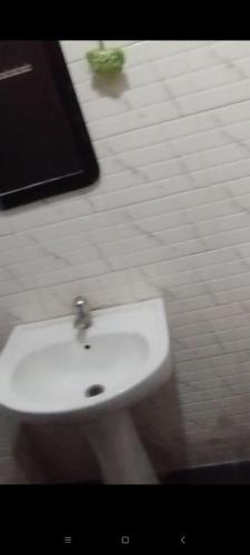 a bathroom with a white sink in a room at Krishna Divine 2 Bedroom Home in mayapur