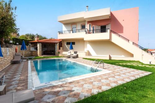 uma villa com piscina em frente a uma casa em Villa Pantelis with private pool em Agia Triada