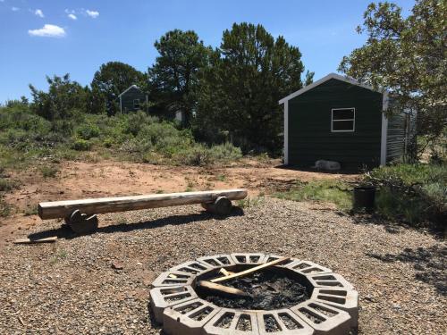 a fire pit and a bench in a yard at Lupine Cabin, Glamour Camping, Stunning Skies and Sunrise Views in Monticello