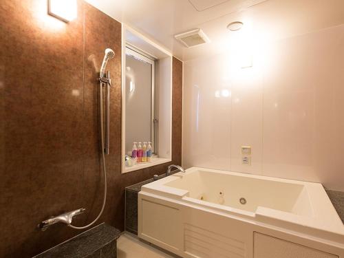 a bathroom with a large tub and a shower at HOTEL PARIET Nakagawa - Adult Only in Fukuoka