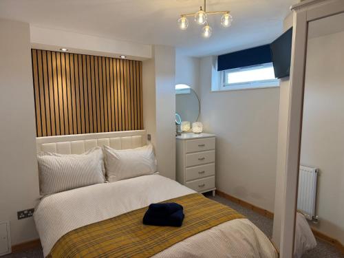 a bedroom with a bed with a black hat on it at Stylish Saundersfoot Top Floor 2-Bed Seaview Apartment, Balcony & Parking in Pembrokeshire