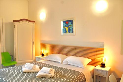 比萨麦泡泡比萨住宿加早餐旅馆的一间卧室，有一张大床，床上有两条毛巾