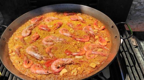 a pan of food with shrimp on a stove at Hotel Beatriz in Burriana