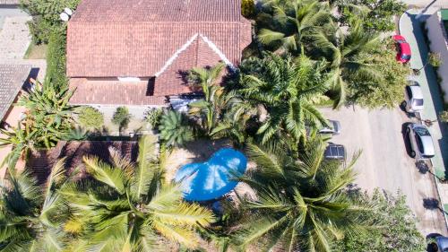 an overhead view of a house with palm trees and a blue pool at Pousada Chalé Suíço in Paraty