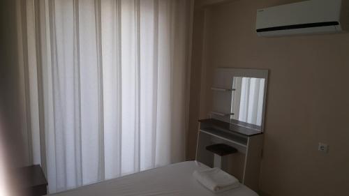 a bedroom with a bed and a sink and a mirror at Karya Apartments in Koycegiz
