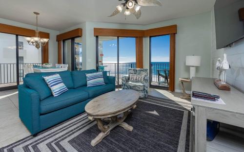 a living room with a blue couch and a table at Phoenix VI 61115 in Orange Beach